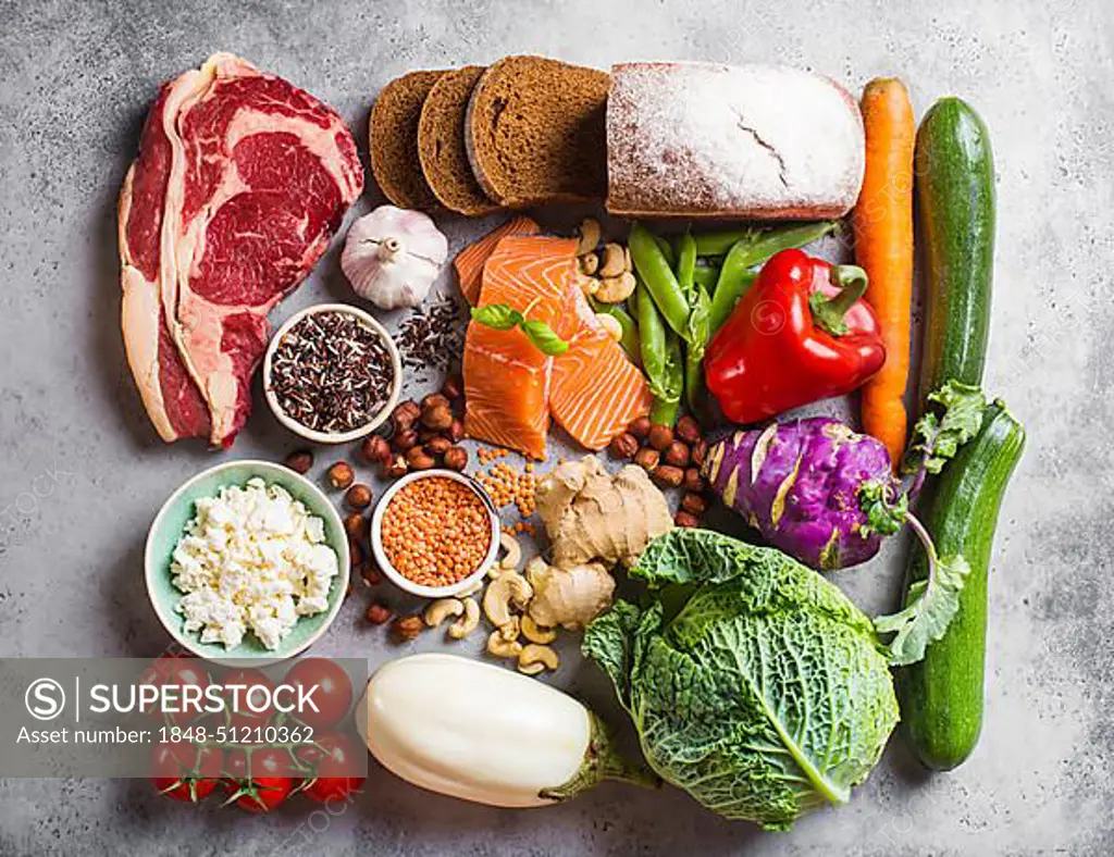 Assortment of healthy balanced food composition: meat, fish, vegetables, bread, cereals, beans, stone background. Raw ingredients for cooking healthy meal, good for diet, clean eating concept