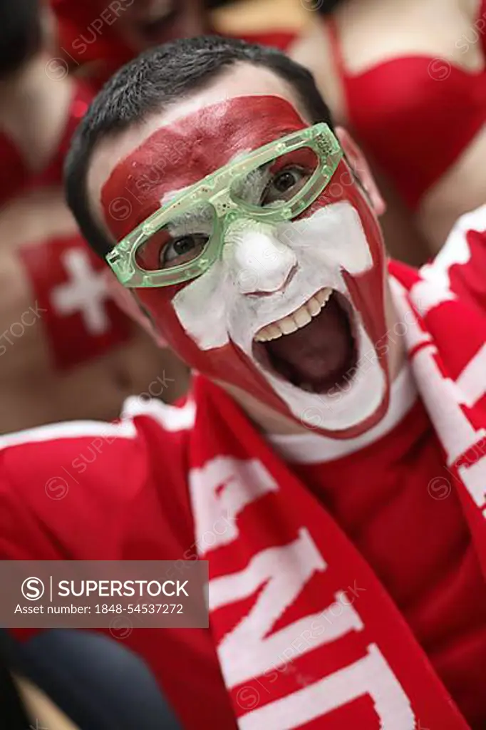 Football fan with their face painted in the Swiss national colours