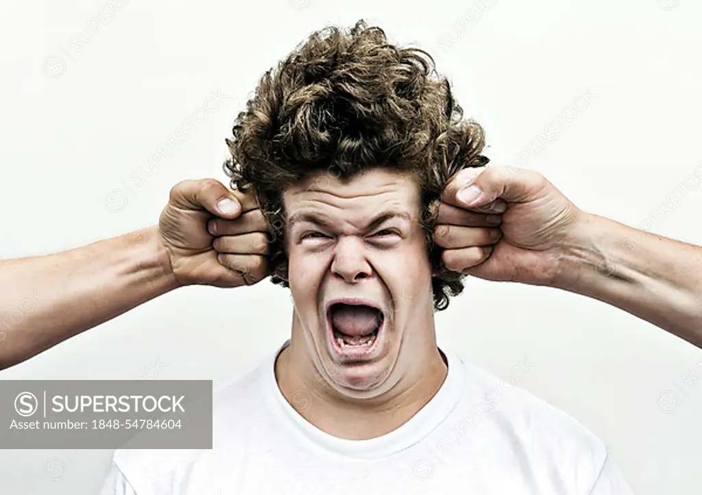 Young man shouting while being attacked by fists, headache