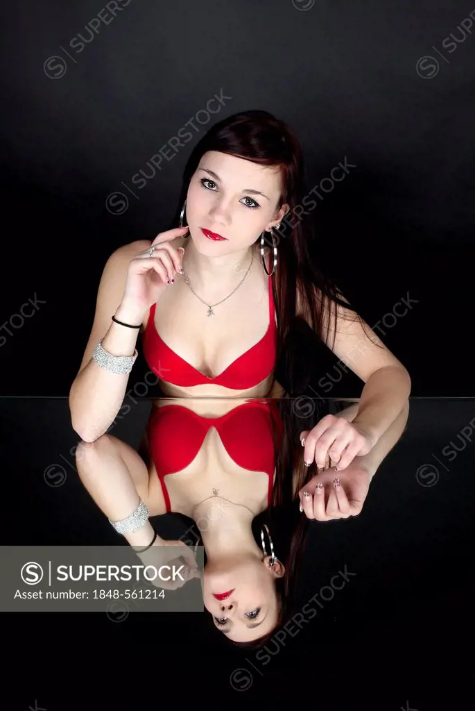 Foto de Young woman in red bra on white background do Stock