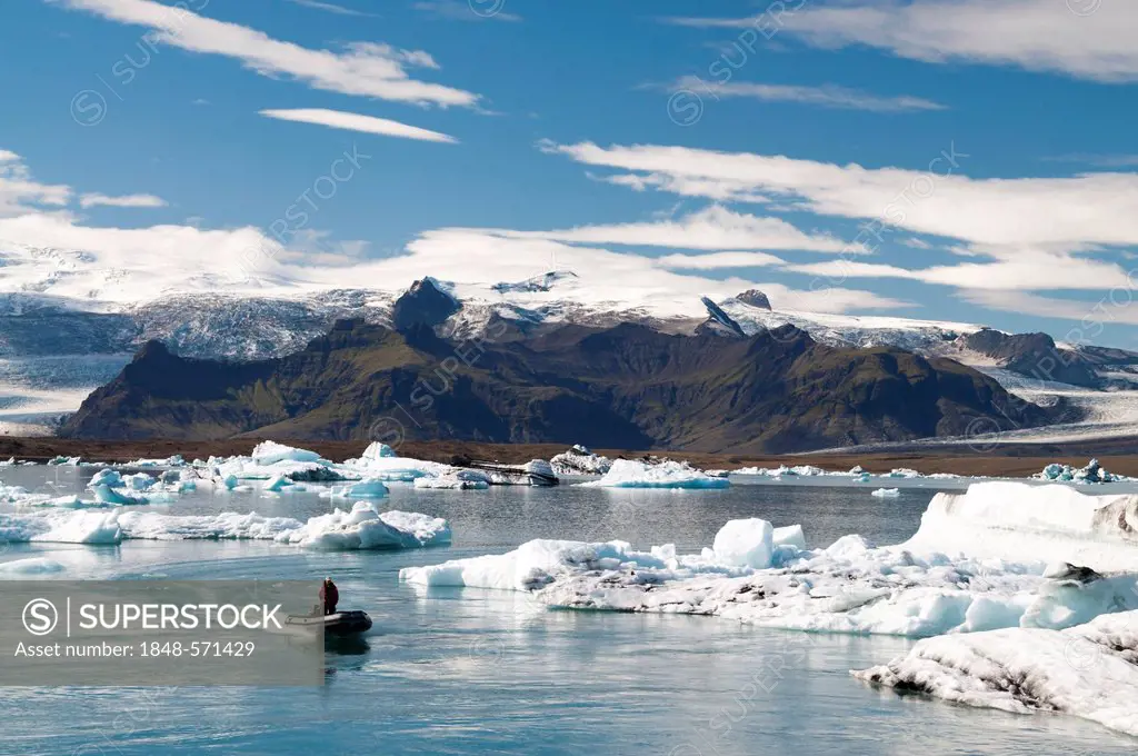 Zodiac raft or inflatable boat, blue and black ash-coloured icebergs, glacier lagoon of Joekulsárlón, Vatnajoekull Glacier, Austurland, East Iceland, ...