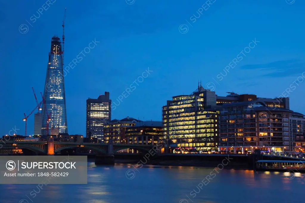 The Shard, London's tallest building under construction, and modern office and residential buildings by the River Thames at dusk, London, England, Uni...