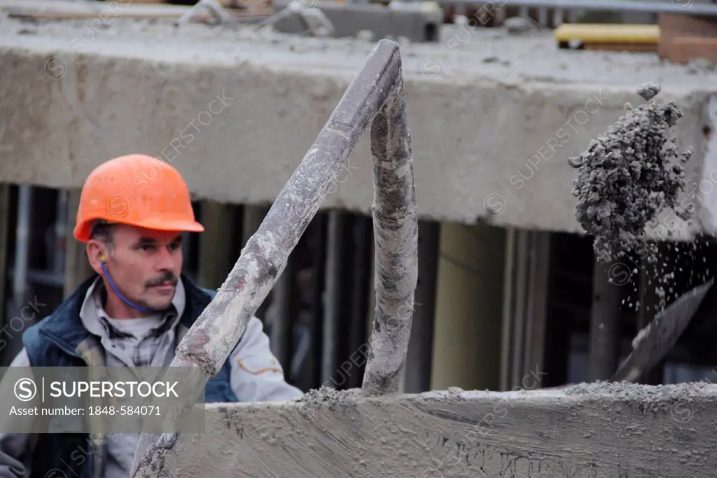 Construction worker shoveling concrete into a container