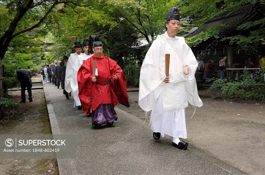 Shinto priests carrying scepters and wearing hats with community members wearing black suits, Nashinoki Shrine, Kyoto, Japan, East Asia, Asia