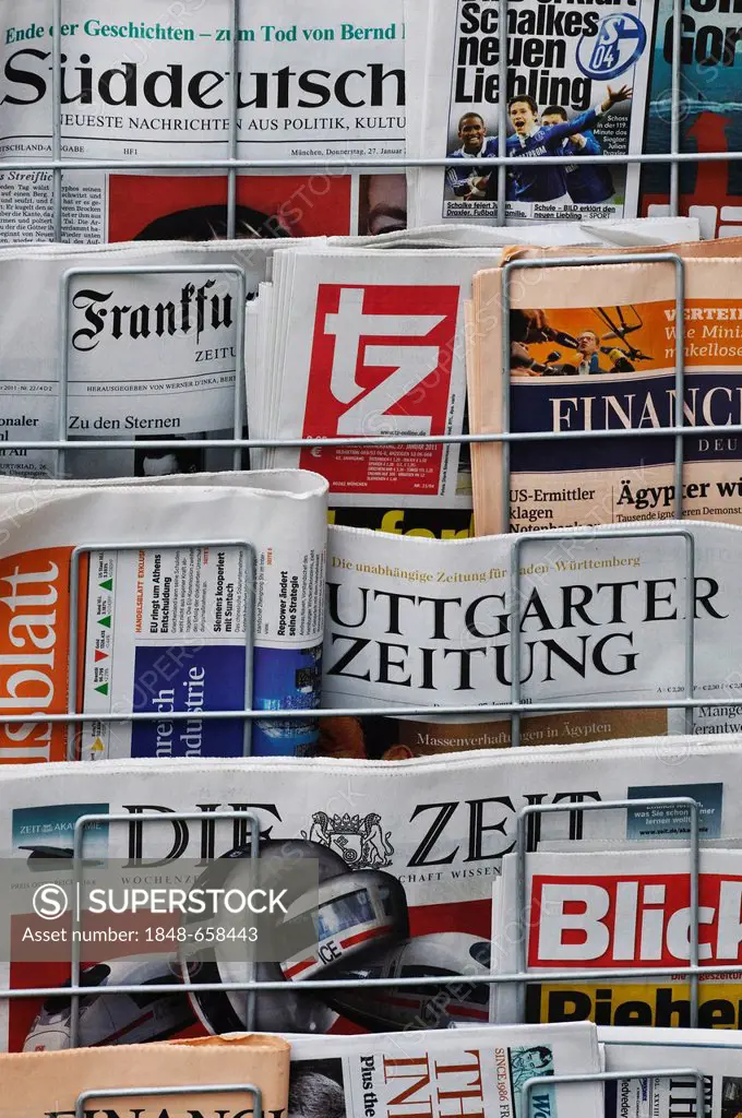 Various newspapers in a newspaper display stand