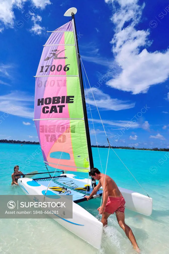 Tourists sliding catamaran into the sea, St. Regis Bora Bora Resort, Bora Bora, Leeward Islands, Society Islands, French Polynesia, Pacific Ocean