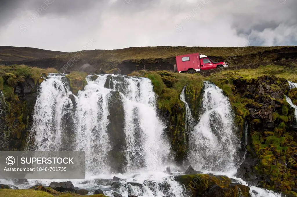 Car crossing a ford above a waterfall on Holmsá River, landscape near Mælifell, Highland, Iceland, Europe