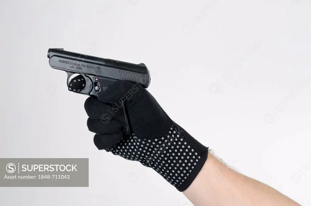 Hand wearing a black glove holding a gun