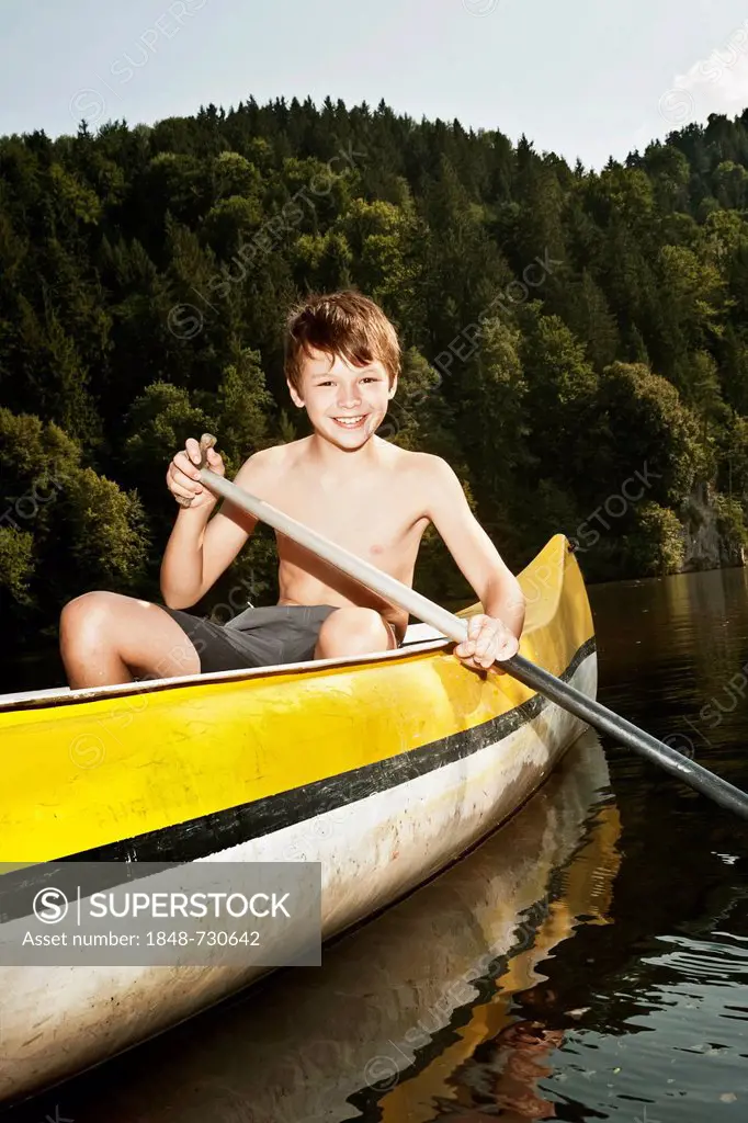 Boy paddling in a canoe