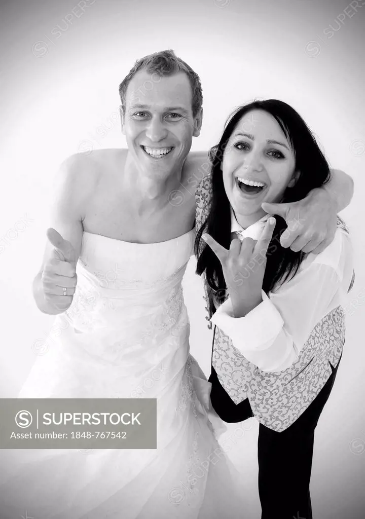 Smiling bride wearing a suit and a groom wearing a wedding dress, exchange of wedding clothing