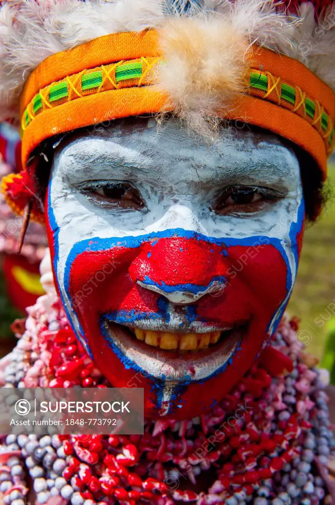 Woman in a colourfully decorated costume with face paint at the traditional sing-sing gathering