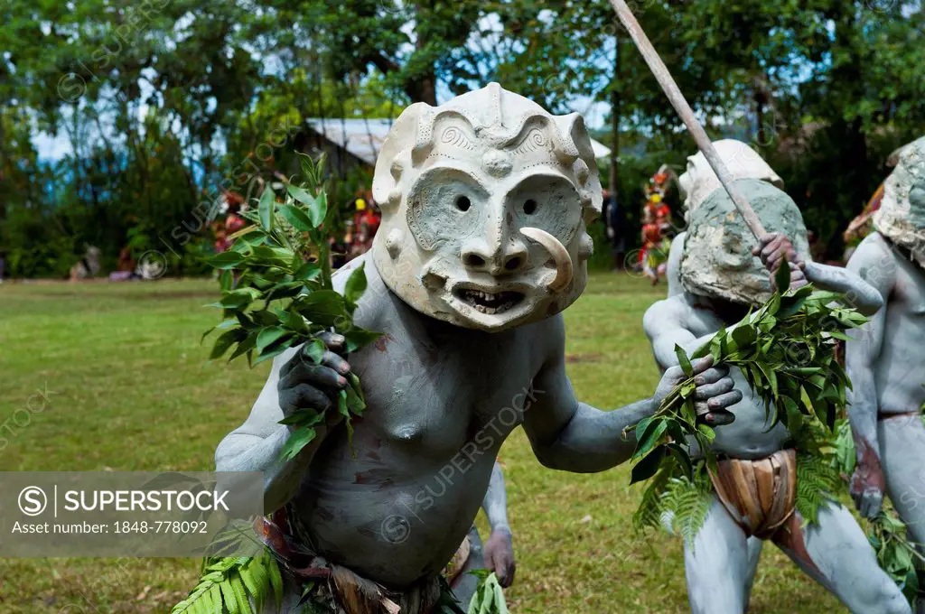 Tribal members in masks and full body paint are celebrating at the traditional Sing Sing gathering in the highlands