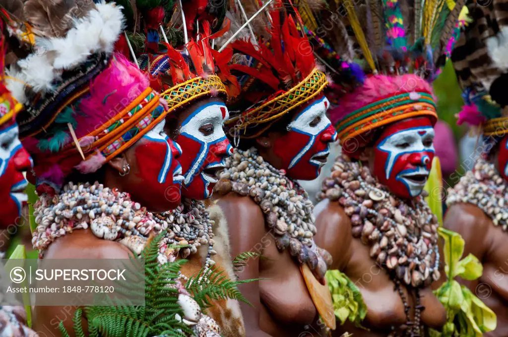 Women in colourfully decorated costumes with face paint are celebrating at the traditional Sing Sing gathering in the highlands