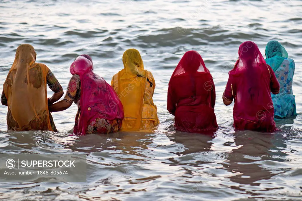 Hindu pilgrims, women in colourful saris taking a holy bath om the sea before sunrise, at the Ghat Agni Theertham, Rameswaram, Pamban Island, Tamil Na...