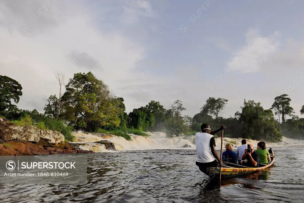 Boat in front of the cascades where the Lobé River plunges over 30 meters into the Atlantic, Kribi, South Region, Cameroon