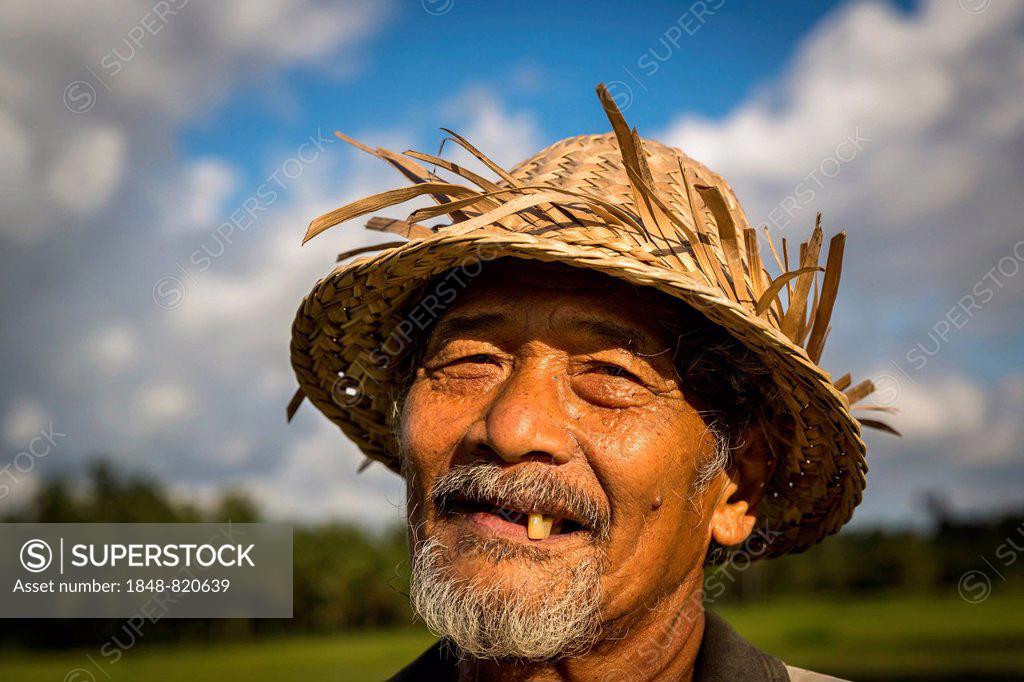 Old Balinese Farmer With Wrinkled Face In Traditional Straw Hat