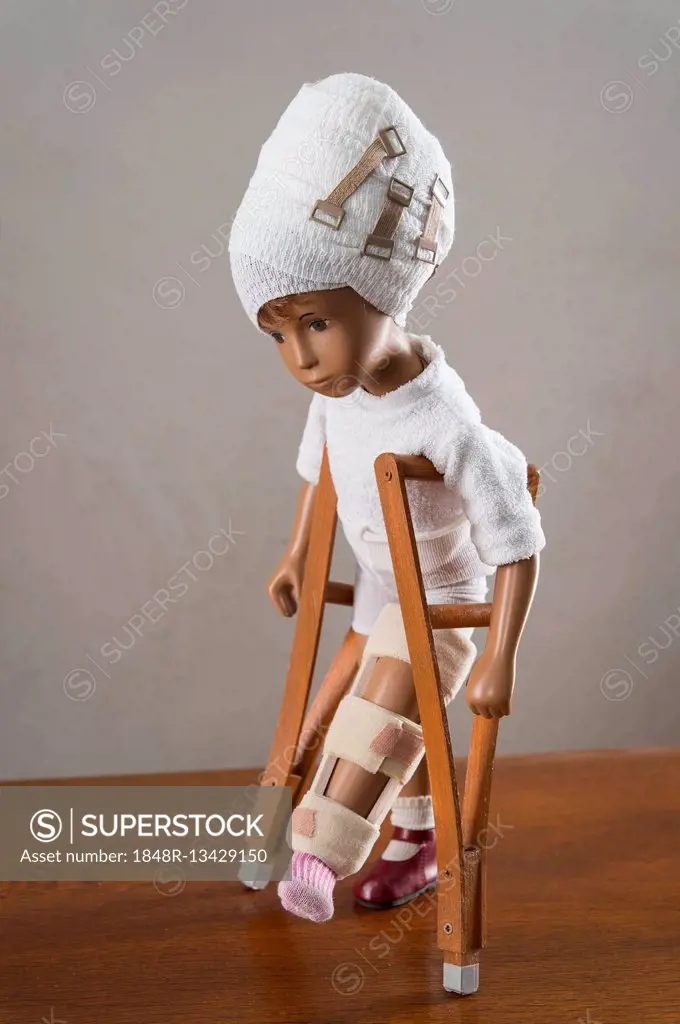 Doll with bandaged head, leg splint, crutches, walking, upright