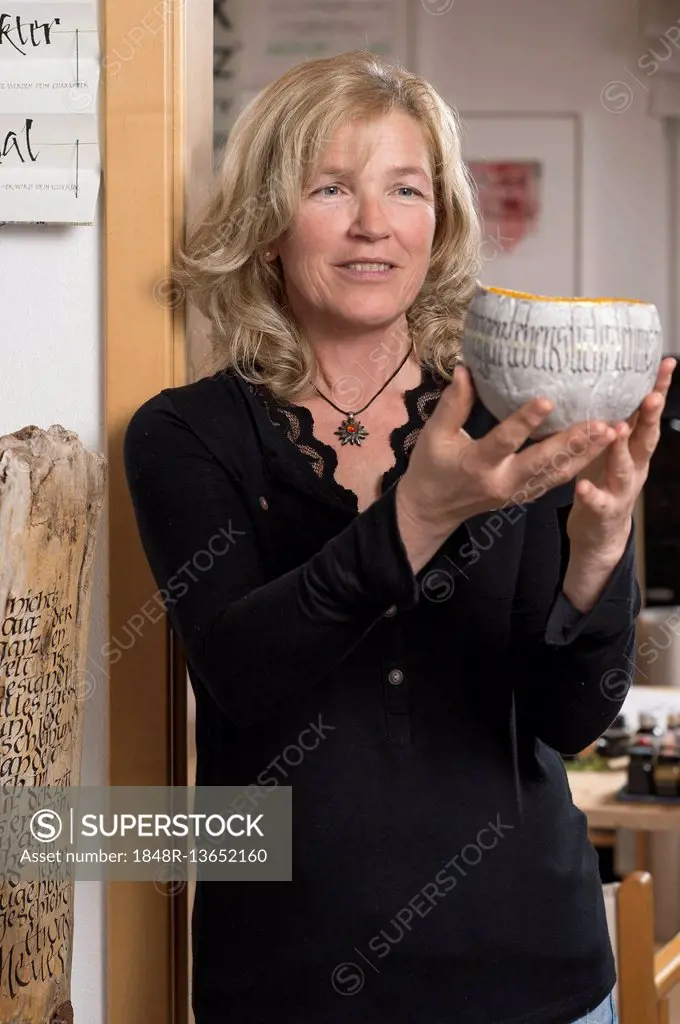 Calligraphy studio, woman holding plaster cast with lettering, Seebruck, Upper Bavaria, Germany