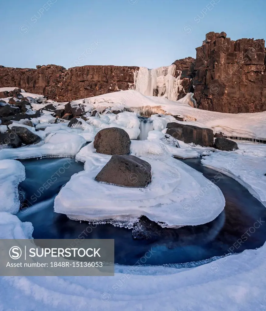 Partially frozen waterfall Öxarárfoss in winter, river Öxará, Pingvellir National Park, Golden Circle, South Iceland, Iceland