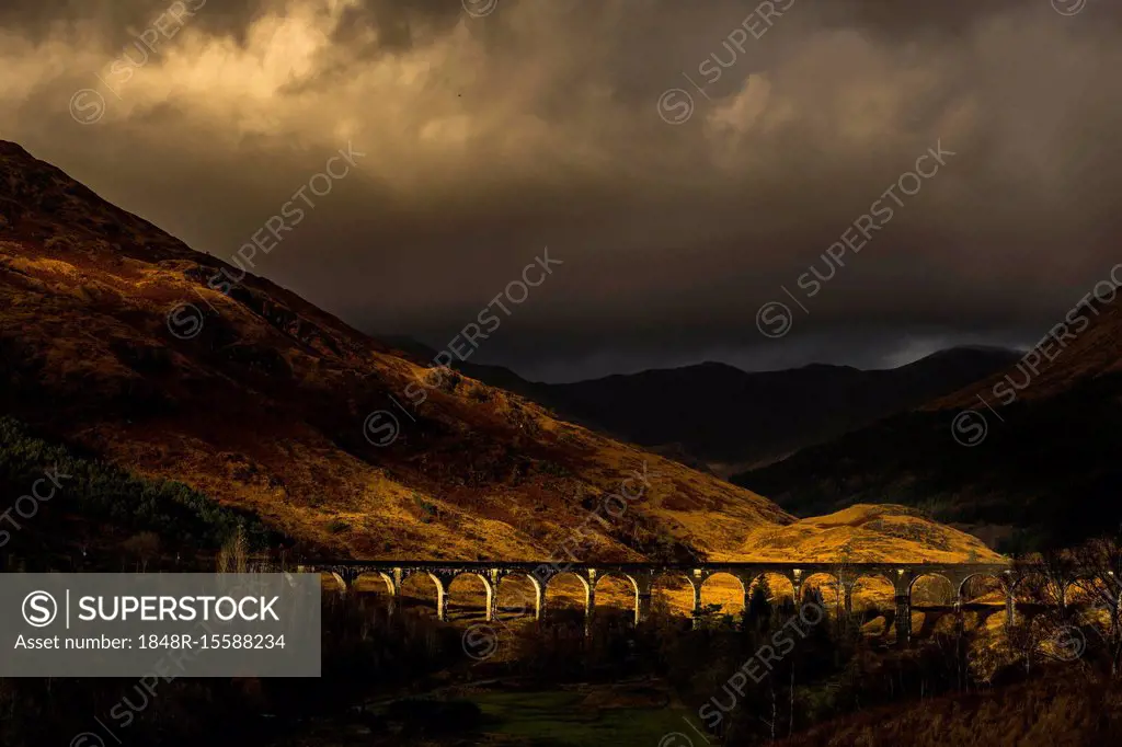 Glenfinnan railway viaduct, with autumn colours and dramatic cloudy skies, Glenfinnan, West Highlands, Scotland, Great Britain