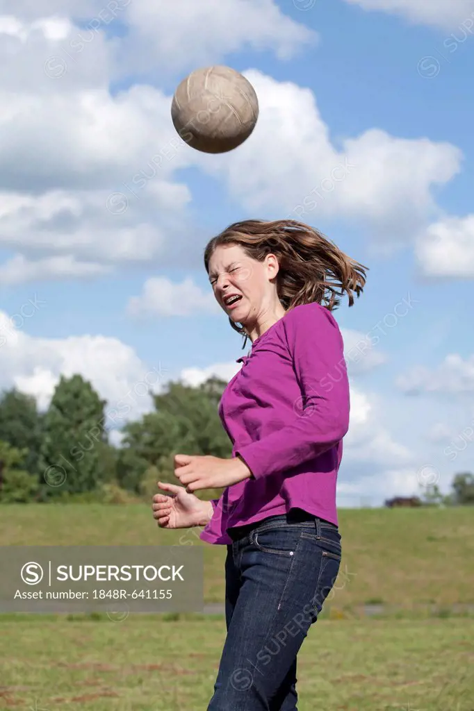 Girl playing football, heading ball