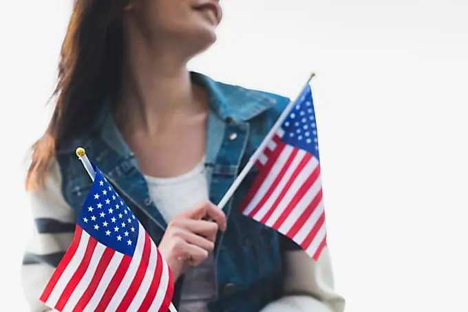 Young smiling lady holding american flags