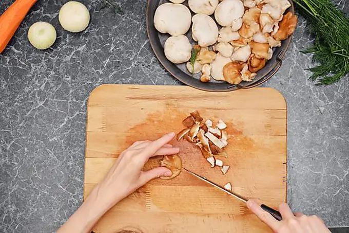 Unrecognizable woman cutting vegetables while making healthy food