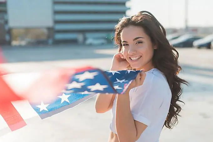 Beautiful woman holding big usa flag