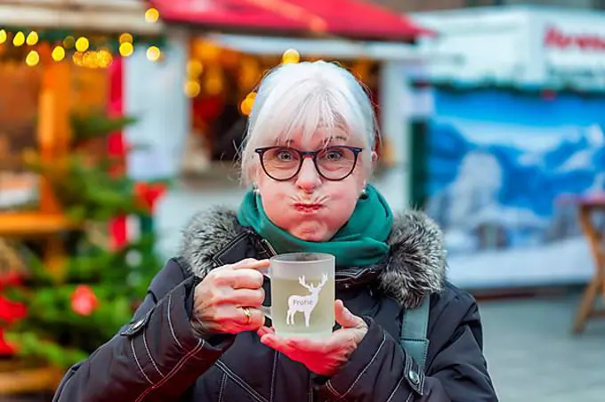 Senior citizen, camera view, frightened, horrified, drinking, mulled wine, Christmas market, Grevenbroich, North Rhine-Westphalia, Germany, public ground, Europe