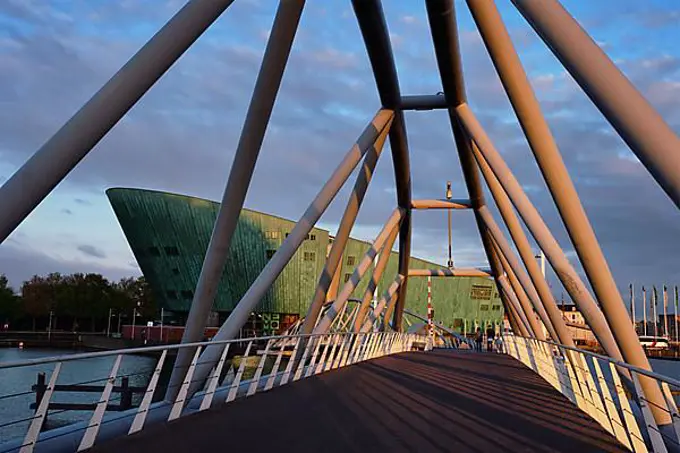 AMSTERDAM, NETHERLANDS, MAY 9, 2017: NEMO Science museum and Mr. J. van der Veldebrug bridge. It is the largest science center in Netherlands with over 500000 visitors per year