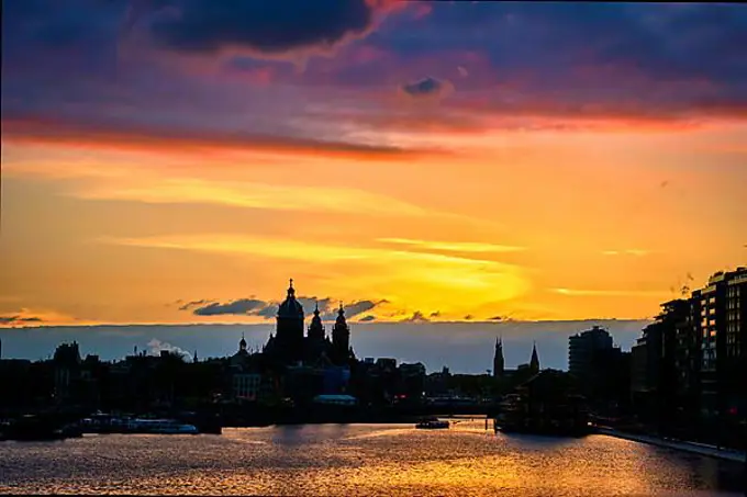 Amsterdam cityscape skyline with Church of Saint Nicholas (Sint-Nicolaaskerk) on sunset with dramatic sky. Amsterdam, Netherlands