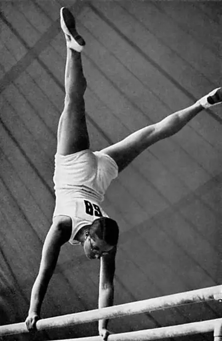 Gymnastics, apparatus gymnastics, the German gymnast Kaete Sohnemann does a handstand with straddled legs on the parallel bars