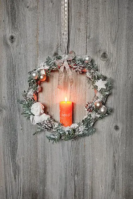 Christmas wreath on wooden wall with candle