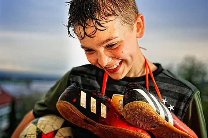 Boy with soccer shoes, Germany, Europe