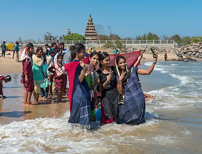 Teenage girls take selfie on the beach in front of Shore Temple, Mahabalipuram, Mamallapuram, India, Asia