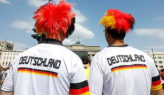 Football fans wear wigs with the colours of the German flag for the World Cup opening match between Germany and Mexico in the fan mile at the Brandenburg Gate in Berlin, 17.06.2018