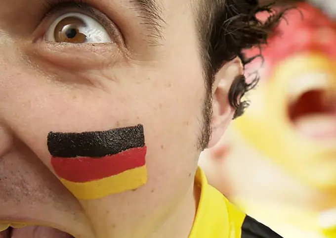 Football fan with his face painted in the national colours of Germany