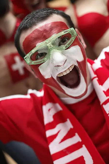 Football fan with their face painted in the Swiss national colours