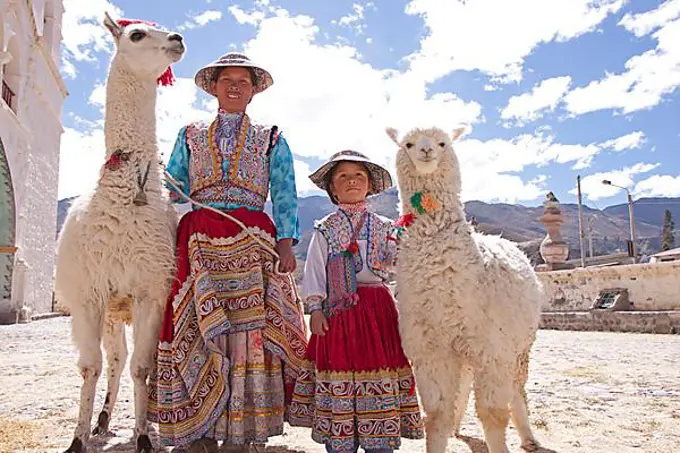 Woman and girl with llama and alpaca in Maca near Colca Canyon, Peru, South America