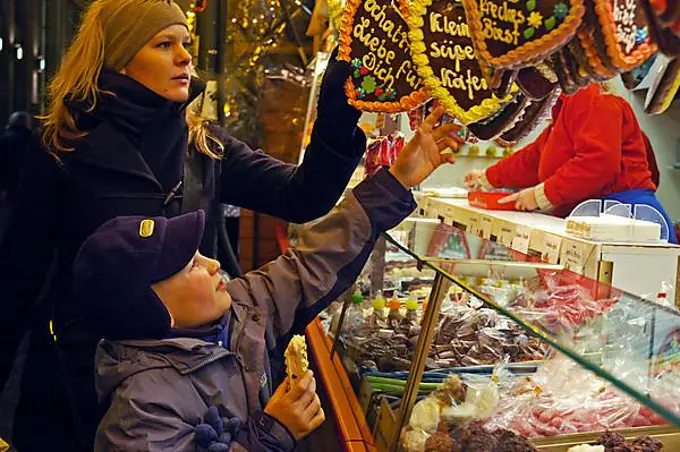 Little boy and young woman at a gingerbread stand, gingerbread, sweets, Christmas fair, Christmas, Dortmund, NRW, Nordrhein Westphalia, Germany, Europe