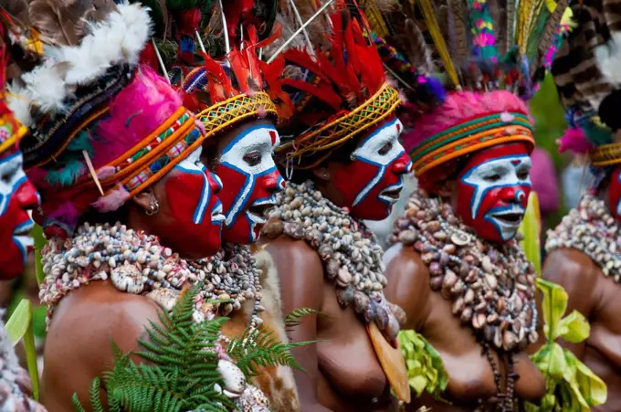 Women in colourfully decorated costumes with face paint are celebrating at the traditional Sing Sing gathering in the highlands