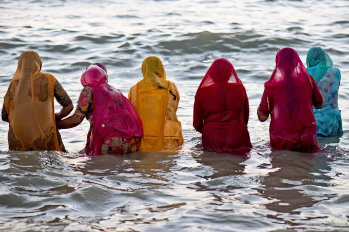 Hindu pilgrims, women in colourful saris taking a holy bath om the sea before sunrise, at the Ghat Agni Theertham, Rameswaram, Pamban Island, Tamil Na...