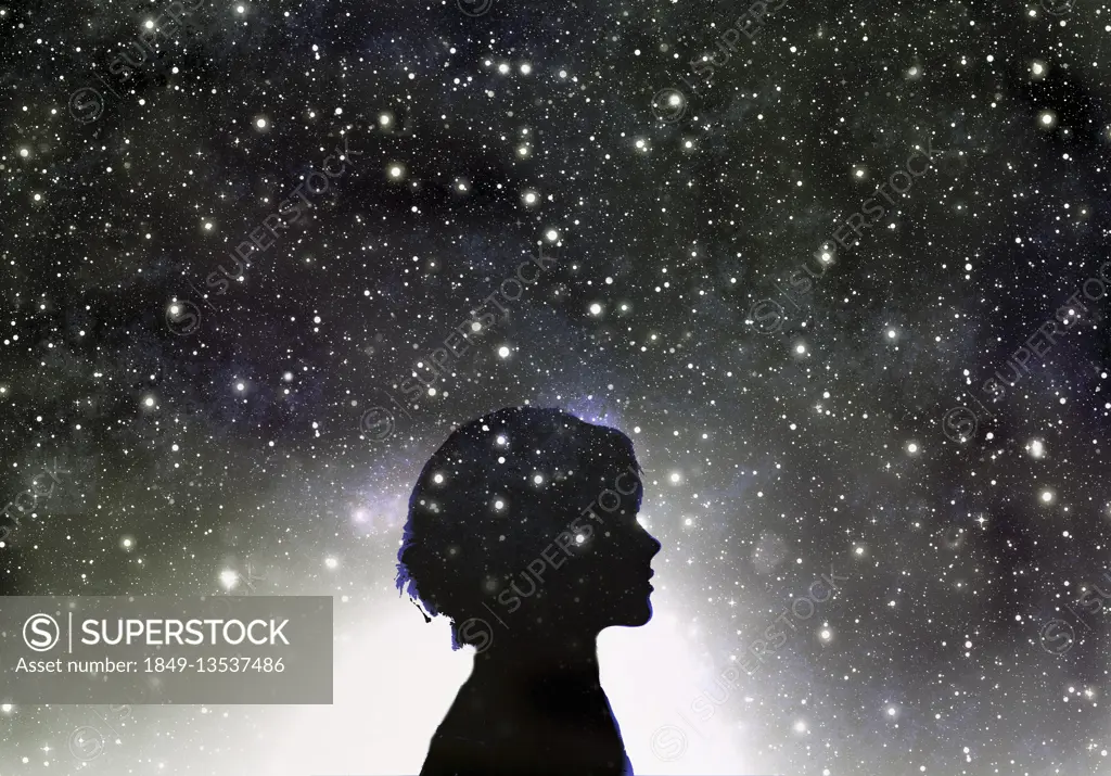 Silhouette of woman's head in galaxy of stars