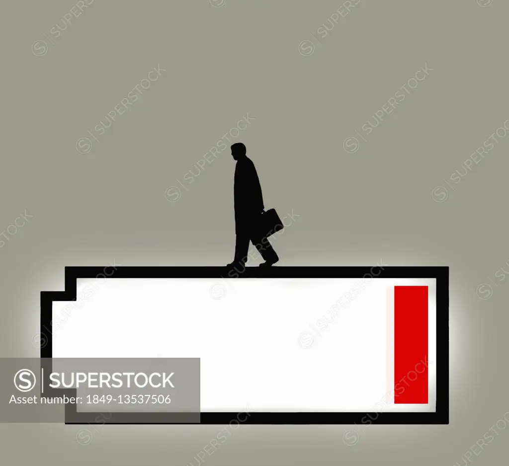 Businessman walking on top of low battery symbol