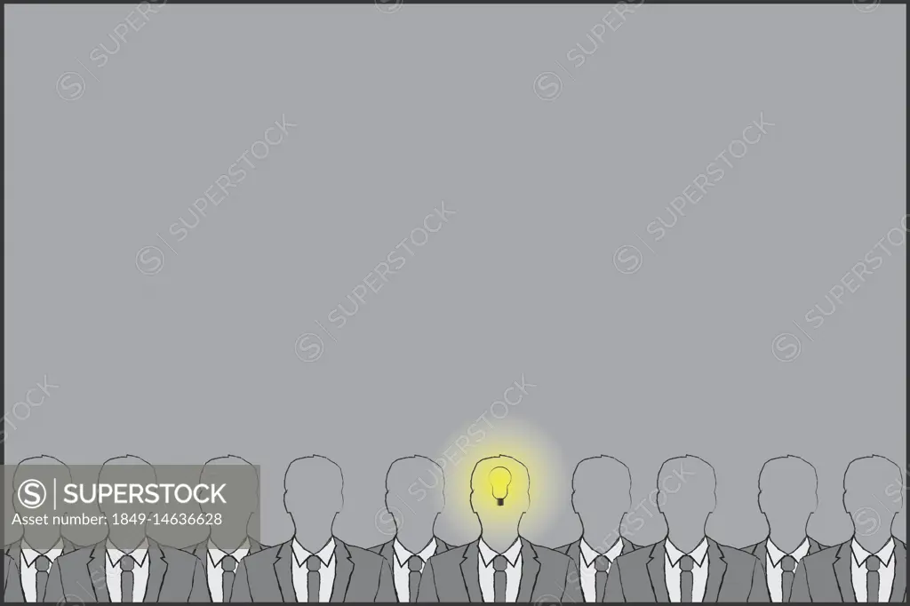 Businessman with light bulb lit up in head standing out from the crowd