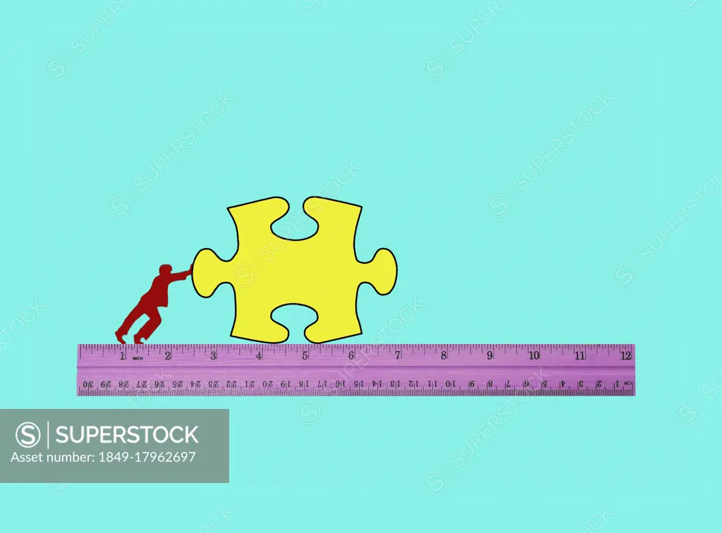 Man pushing jigsaw puzzle piece along ruler