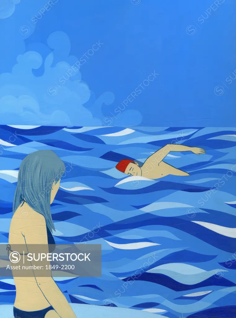 Woman watching man swim in ocean