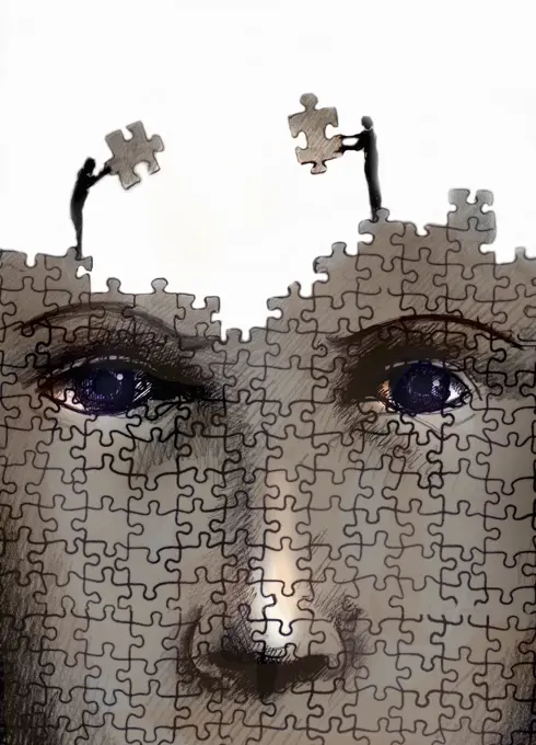 Man and woman working together on large jigsaw puzzle of human face