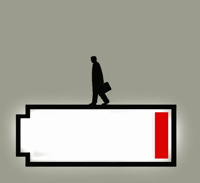 Businessman walking on top of low battery symbol