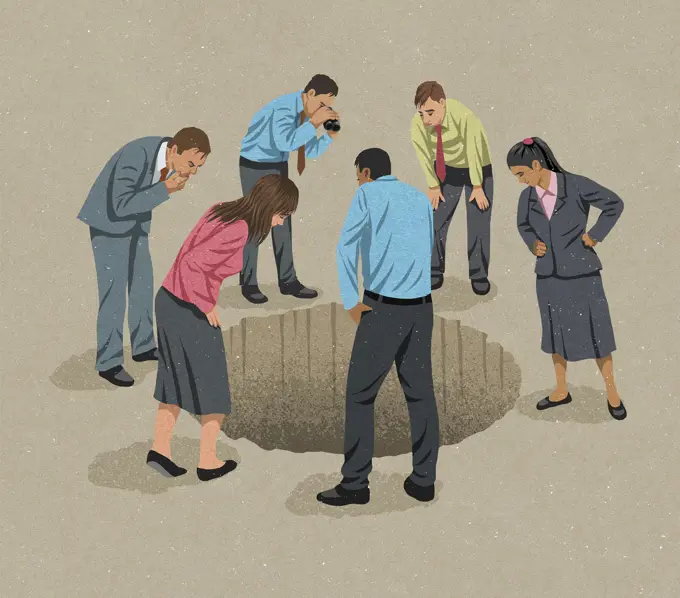 Business people looking down into hole